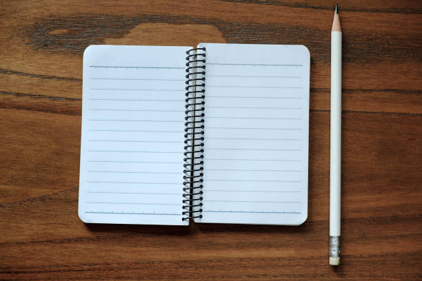 istock Blank notebook with pencil on brown wood table 866947550