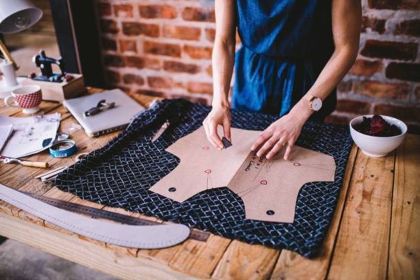 Young woman drawing template for dress design