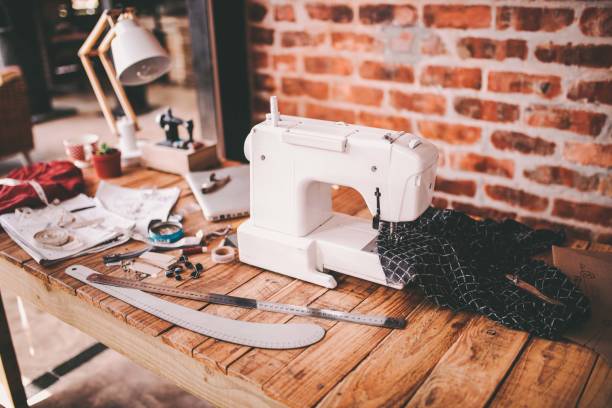 Desk of fashion designer with sewing machine and tools Desk of fashion designer with sewing machine and tools sewing machine stock pictures, royalty-free photos & images