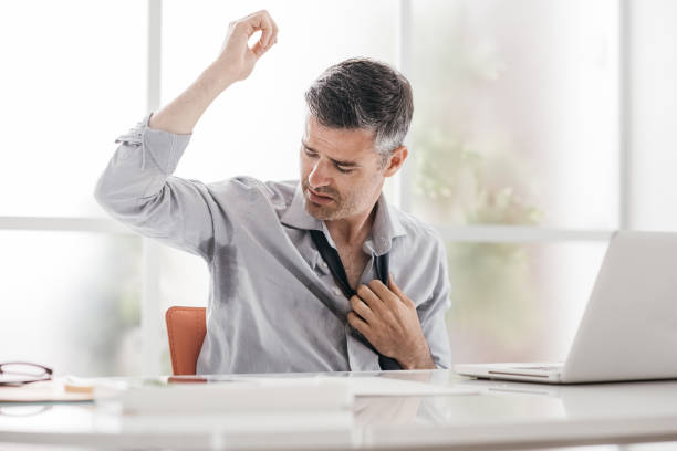 Nervous businessman sweating Nervous businessman working in the office, he is sweating and checking his armpits panicle stock pictures, royalty-free photos & images