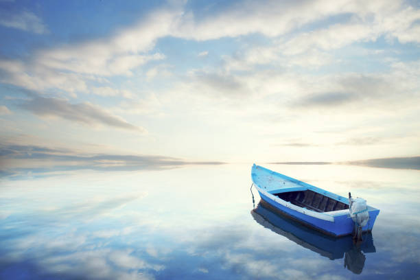 kano drijvend op het rustige water onder geweldige zonsondergang - recreatieboot stockfoto's en -beelden