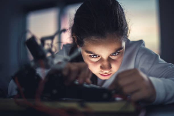 Doing some overtime Young girl working on robotics arm. robotic arm lab stock pictures, royalty-free photos & images