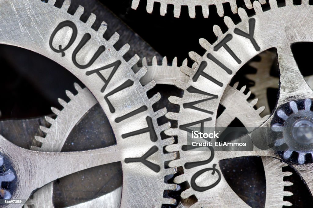 Metal Wheel Concept Macro photo of tooth wheel mechanism with imprinted QUALITY, QUANTITY concept words Abundance Stock Photo