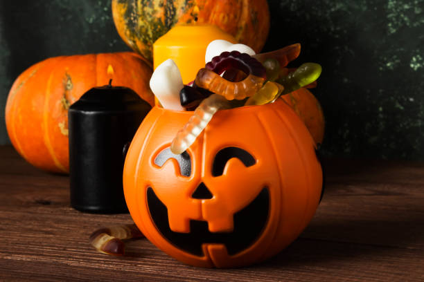 istock Terrible sweets for Halloween in decorative pumpkin on a dark background 866977466