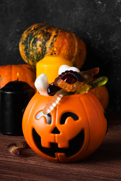 istock Terrible sweets for Halloween in decorative pumpkin on a dark background 866979072