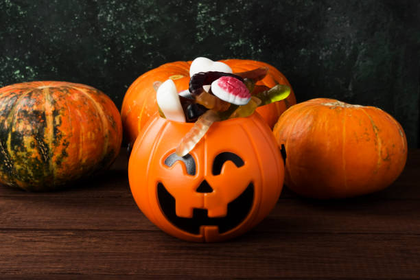 istock Terrible sweets for Halloween in decorative pumpkin on a dark background 866979084