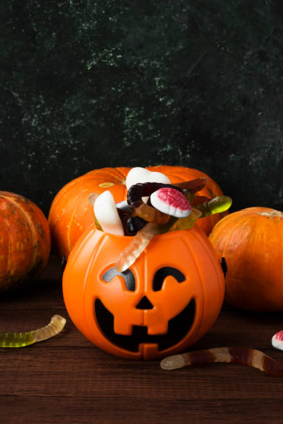 istock Terrible sweets for Halloween in decorative pumpkin on a dark background 866979112