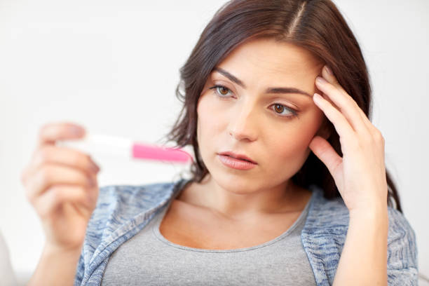 istock sad woman looking at home pregnancy test 866986020