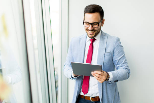 istock Young businessman with digital tablet in office 866988340