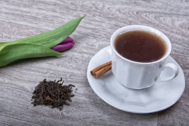 istock A cup of tea with cinnamon and purple tulips 866994812