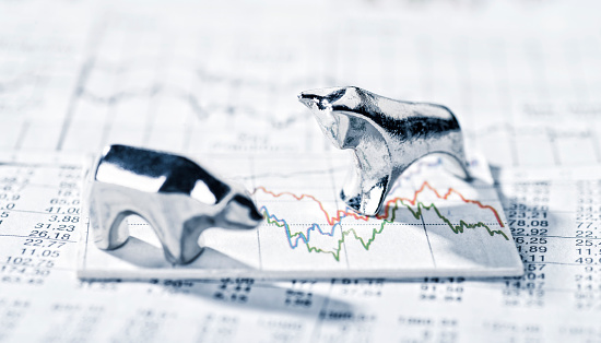 Bull and bear are on a chart with stock market prices.