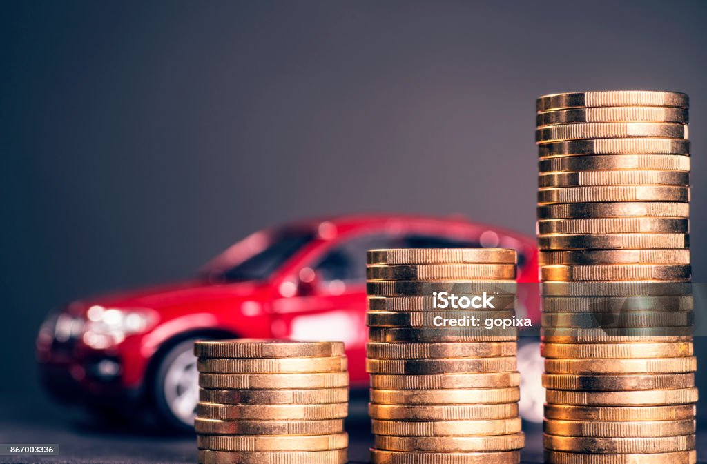 Rising car costs Rising stacks with coins and a red car in the background Car Stock Photo