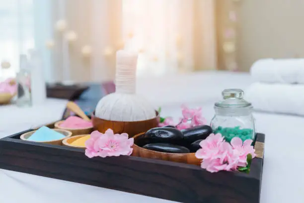 Photo of Thai Herbal Compress , hot stones , salt water prepared on massage table for Thai traditional massage and spa treatment