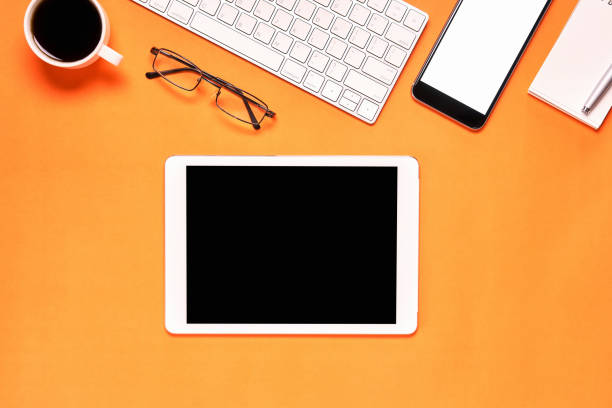 istock Top view, Modern workplace with laptop and tablet with smart phone placed on a pastel yellow background. Copy space suitable for use in graphics. 867007016