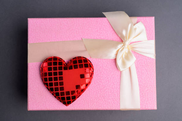 istock Pink Gift Box With Red Heart Against Gray Background 867009626
