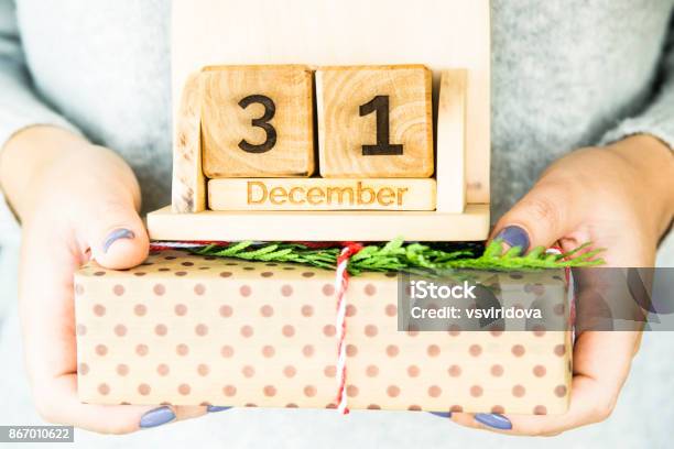 Woman Holding A Wooden Calendar With The Date Of New Years Day December 31 Stock Photo - Download Image Now