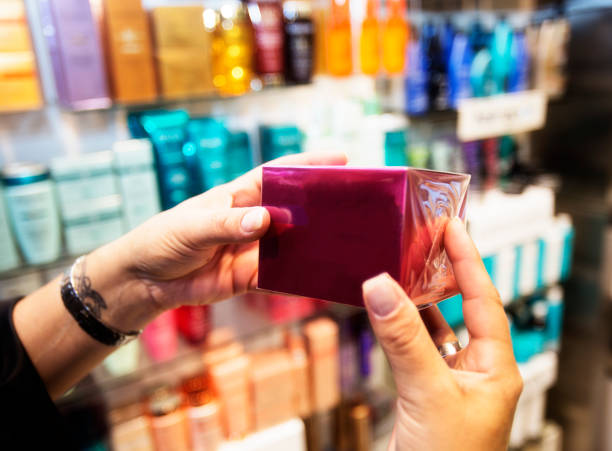 Womans hands hold a red box in a cosmetic store aisle while shopping
