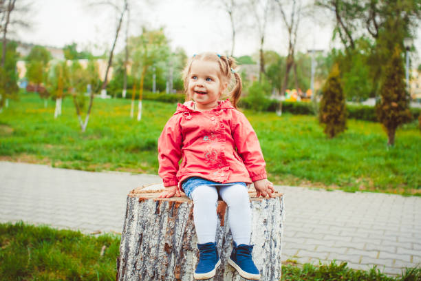 istock girl sitting on a stump 867018012