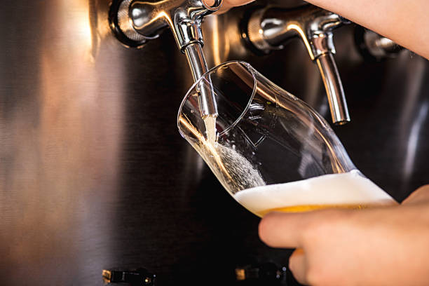 istock Hand of bartender pouring a large lager beer in tap 867019448