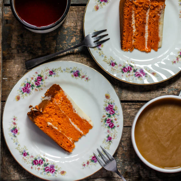 piece of orange cake with white cream on a wooden table