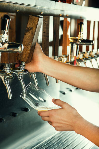 istock Hand of bartender pouring a large lager beer in tap 867023218