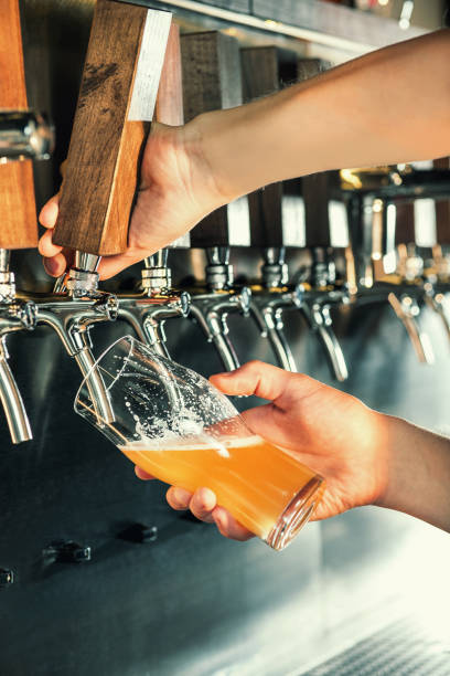 istock Hand of bartender pouring a large lager beer in tap 867023568