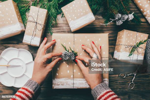 Woman Wrapping Christmas Presents In A Crafty Way Stock Photo - Download Image Now - Gift, Wrapping Paper, Christmas