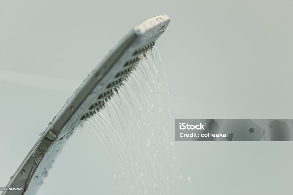 Low water pressure problem closeup at shower head in white bathroom Low Stock Photo