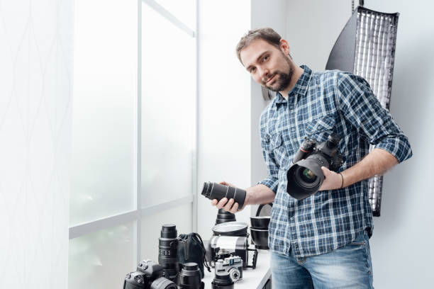 fotograf wybierający obiektyw - picking up flash zdjęcia i obrazy z banku zdjęć