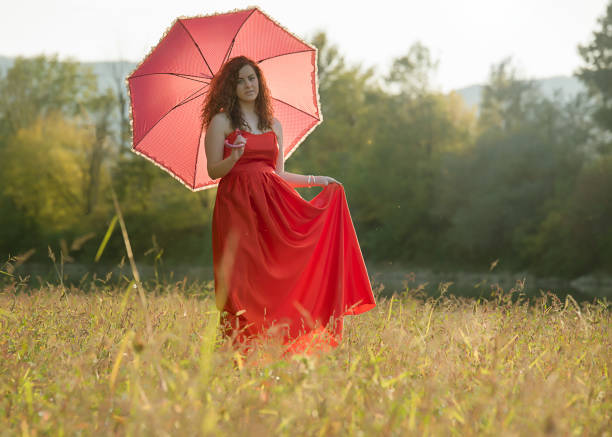 Young woman jumping with green umbrella at the park