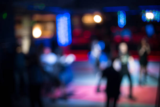 istock People dancing having fun and relax in a night club blurred background. Beautiful blurry lights on the dance floor, in the center of attention to have a rest in night club 867053738