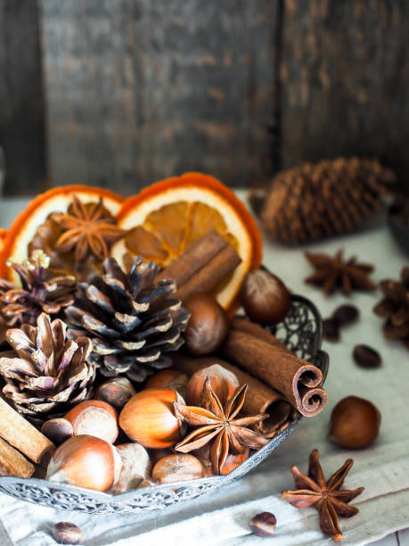 istock Winter ingredients nuts, cones, oranges, cinnamon star anise in a bowl. Rustic style 867056304