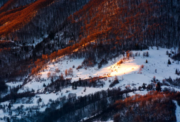 hillside in red light on winter sunrise. beautiful nature scenery in mountains