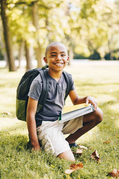 niño listo para ir a la escuela en el parque - outdoors book reading accessibility fotografías e imágenes de stock