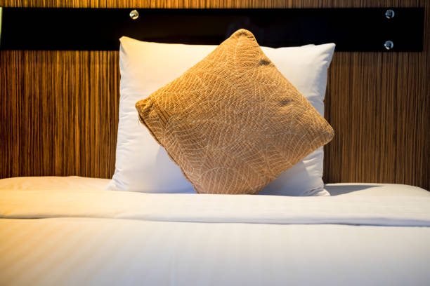 istock White and brown pillow in white bed in hotel room 867061408