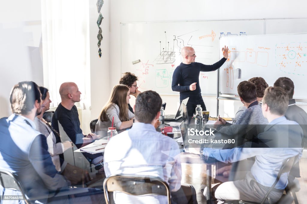 Relaxed informal IT business startup company team meeting. Relaxed informal IT business startup company meeting. Team leader discussing and brainstorming new approaches and ideas with colleagues. Startup business and entrepreneurship concept. Education Training Class Stock Photo