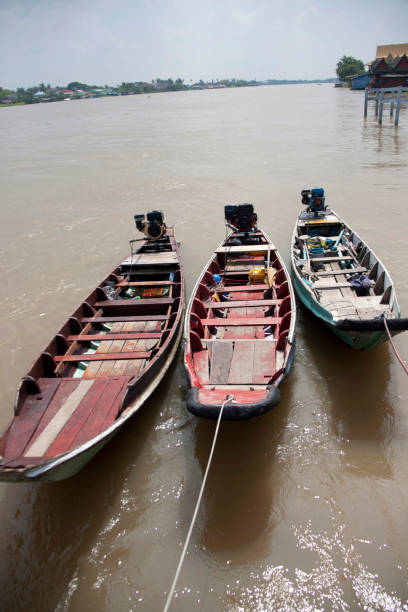 istock Three wooden boat machine landing on the water in the river. 867067036
