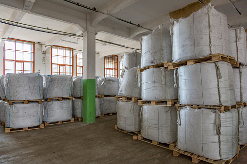 Food sugar in large white bags is stored in a food production warehouse