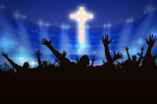 Silhouette of Christian prayers raising hand while praying to the Jesus stock photo