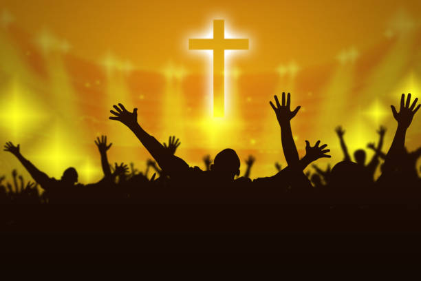 Silhouette of Christian prayers raising hand while praying to the Jesus stock photo