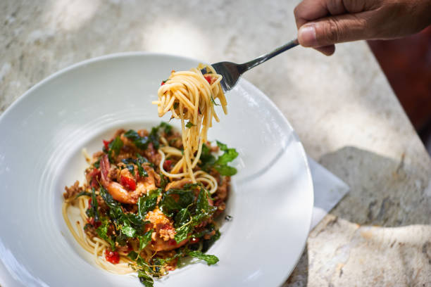 istock Basil spaghetti with spicy aroma. crispy shrimp roll line spaghetti on a plate on the white marbled brown. 867083368