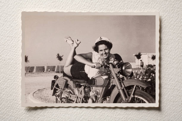 Smiling girl on motorbike at the sea. Photograph of the 50s. Old photograph of a smiling girl on motorbike pin up girl photos stock pictures, royalty-free photos & images