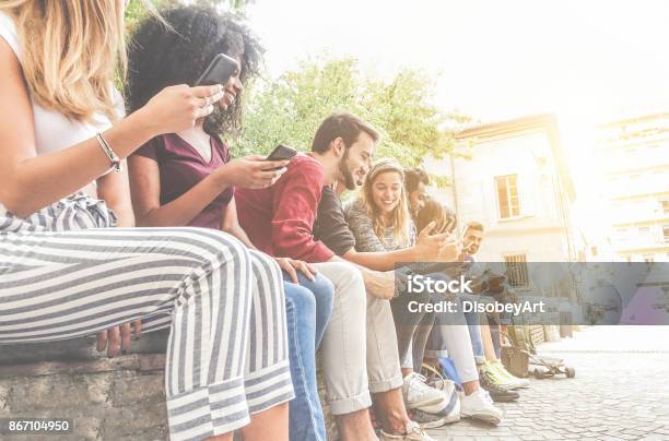 Photo libre de droit de Amis De Diversité Culturelle À Laide De Smartphones En Plein Air banque d'images et plus d'images libres de droit de Messagerie en ligne