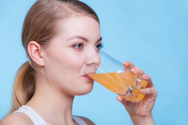 istock Woman drinking orange flavored drink or juice 867107470