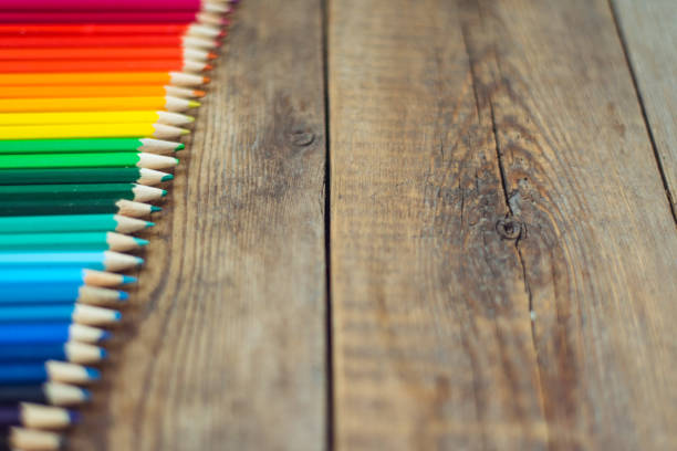 istock Colored pencils in gradient order located at the edge on wooden table. School concept. Copy space 867113684