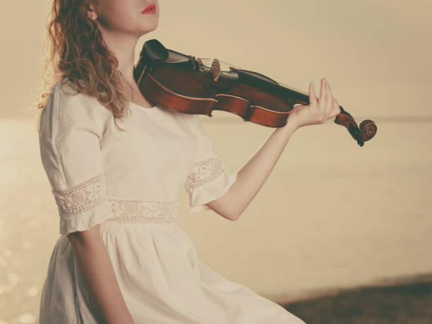 istock Woman on pier outside holding violin 867114176