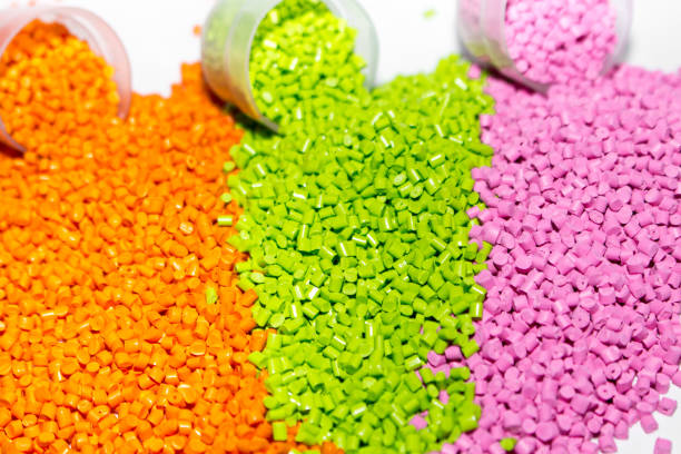 istock Plastic pellets. Orange green and pink Polypropylene granules scattered on the lab table . Polymeric dye. 867124860