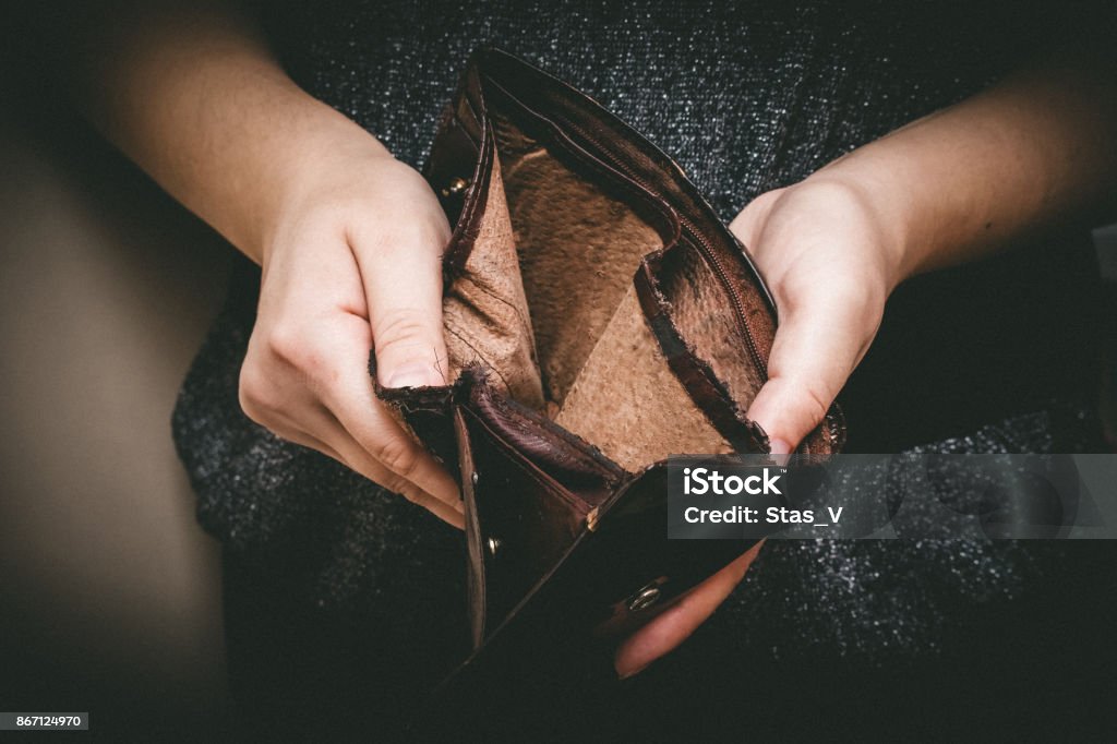 Old empty wallet in the hands .Vintage empty purse in hands of women . Poverty concept, Retirement. Special toning Poverty Stock Photo