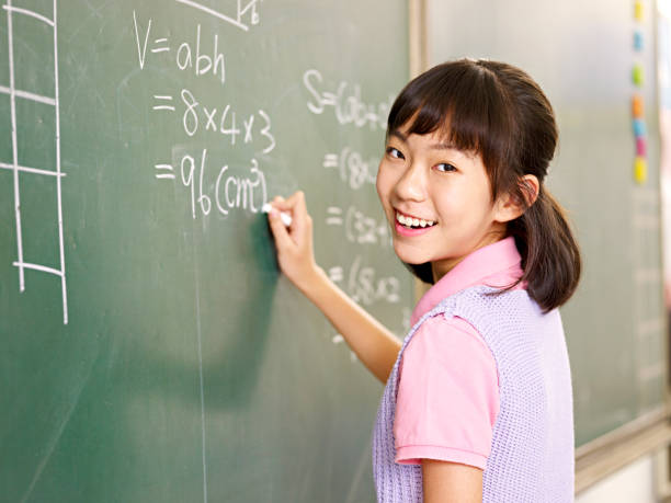 азиатские элементарные школьница решения математических проблем на доске - chinese ethnicity student china asian ethnicity стоковые фото и изображе�ния