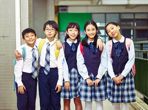 portrait of a group of asian elementary school children wearing uniform.